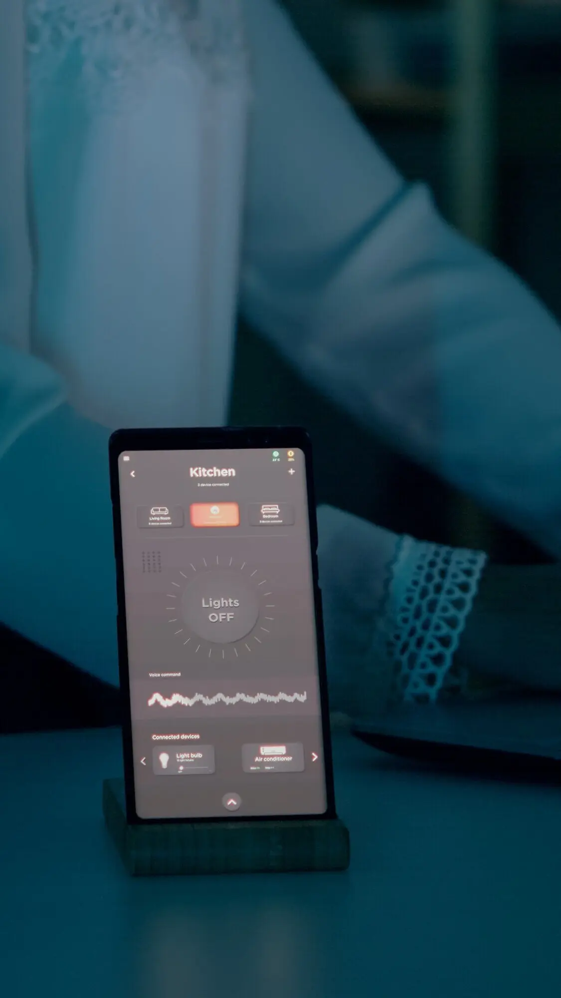 Frau, die zu Hause sitzt und auf einem Laptop tippt, mit einem automatisierten Beleuchtungssystem.